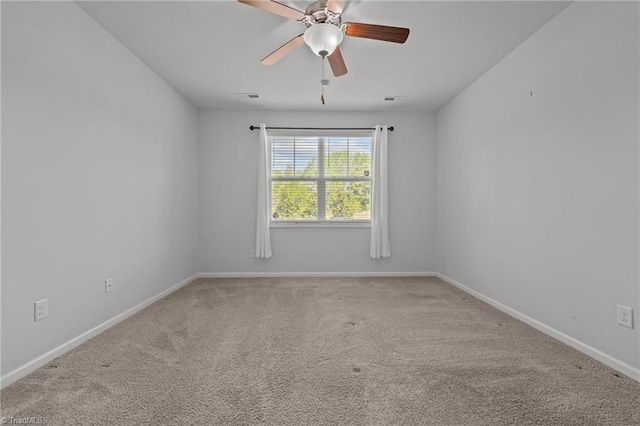 carpeted empty room with visible vents, baseboards, and ceiling fan