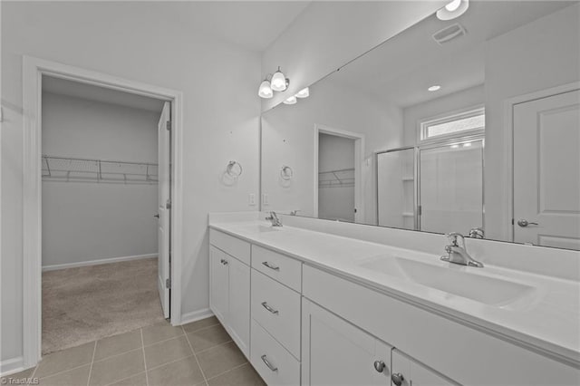 full bath with tile patterned floors, a sink, double vanity, baseboards, and visible vents