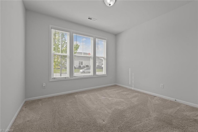 unfurnished room featuring baseboards, visible vents, and carpet flooring