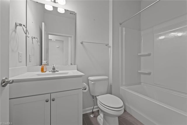 full bath with tile patterned floors, vanity,  shower combination, baseboards, and toilet