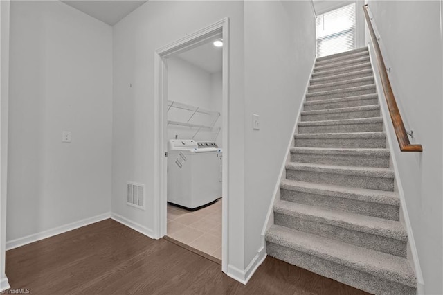 stairway featuring washing machine and dryer, baseboards, wood finished floors, and visible vents