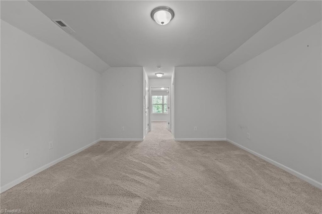 bonus room with light carpet, vaulted ceiling, visible vents, and baseboards