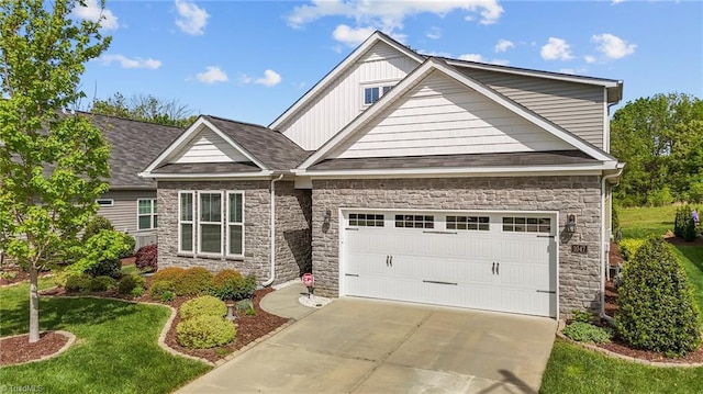 craftsman house with concrete driveway, an attached garage, board and batten siding, stone siding, and a front yard