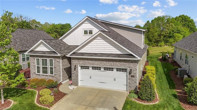 craftsman-style home featuring board and batten siding, roof with shingles, stone siding, and concrete driveway