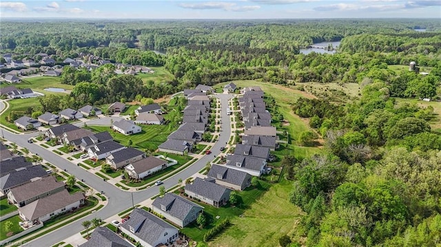 birds eye view of property featuring a forest view, a water view, and a residential view