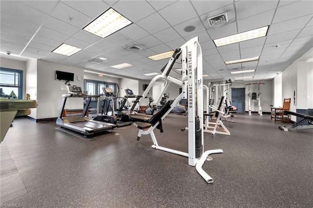 gym featuring a paneled ceiling, visible vents, and baseboards