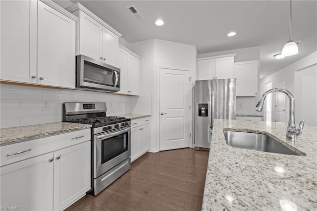 kitchen with white cabinets, appliances with stainless steel finishes, a sink, and visible vents