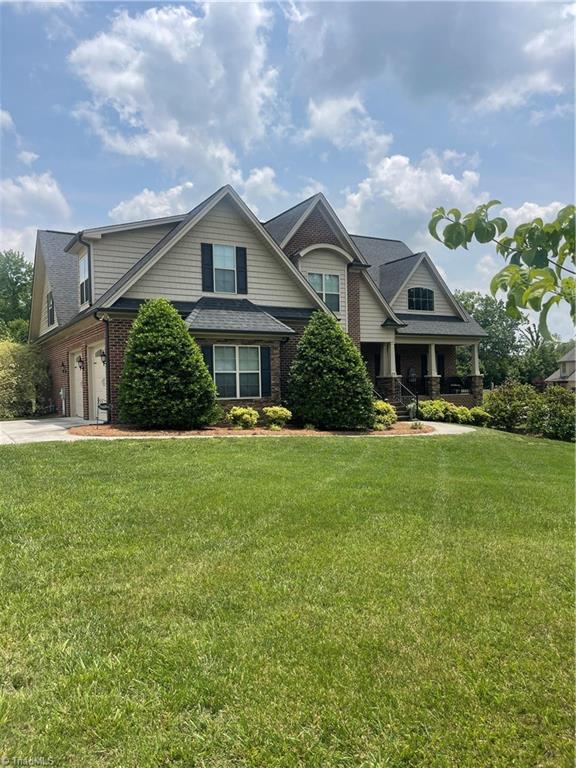 375 Pebblestone Ct, Lexington, NC 27295 - view of front of home with a porch, brick siding, driveway, and a front lawn