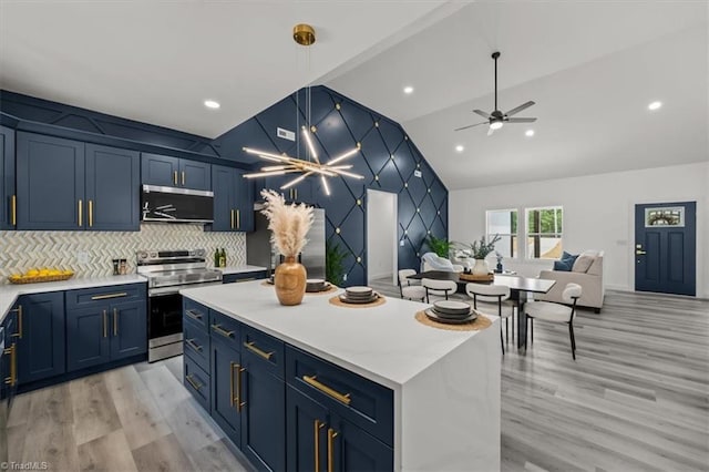 7126 Whitetail Dr, Julian, NC 27283 - kitchen featuring appliances with stainless steel finishes, light wood finished floors, light countertops, blue cabinetry, and vaulted ceiling
