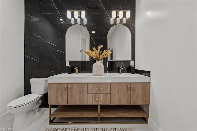 7126 Whitetail Dr, Julian, NC 27283 - bathroom featuring double vanity, toilet, baseboards, and a sink
