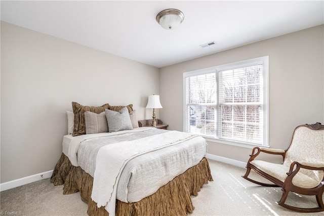 bedroom featuring baseboards, visible vents, and light colored carpet