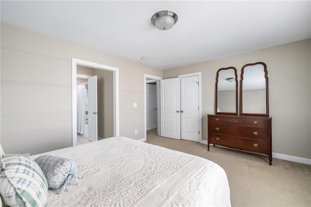 bedroom featuring baseboards, a closet, and light colored carpet