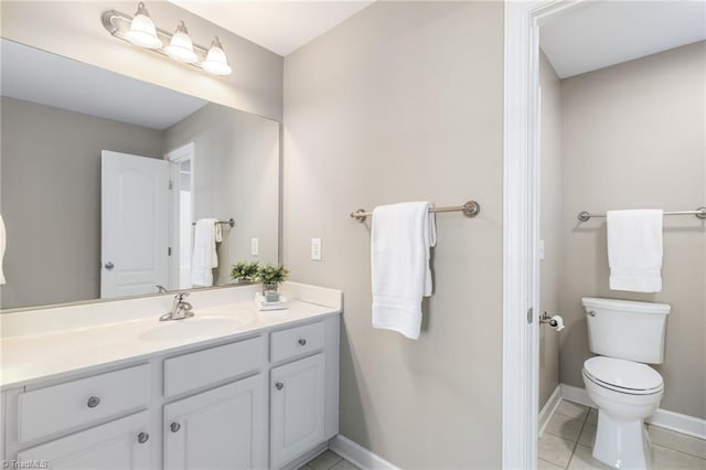 bathroom featuring baseboards, vanity, toilet, and tile patterned floors