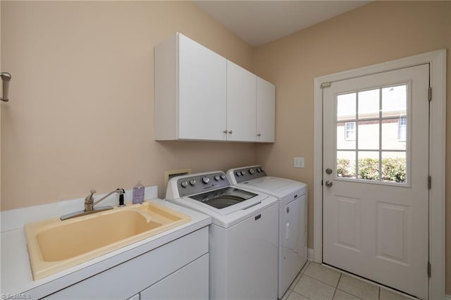 clothes washing area with light tile patterned floors, a sink, cabinet space, and washer and dryer