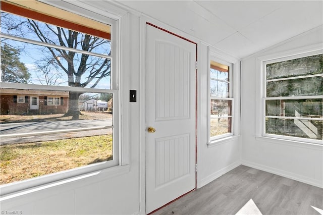 doorway featuring light wood-type flooring and lofted ceiling