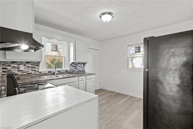 kitchen with black appliances, sink, extractor fan, a healthy amount of sunlight, and white cabinets