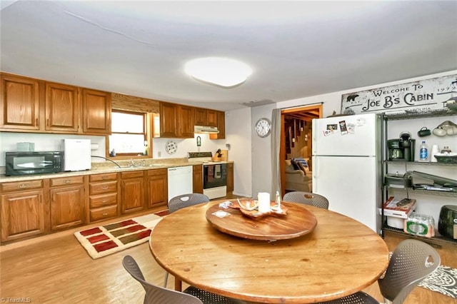 140 Blue Heron Ln, Wilkesboro, NC 28697 - kitchen with white appliances, under cabinet range hood, light countertops, and brown cabinetry