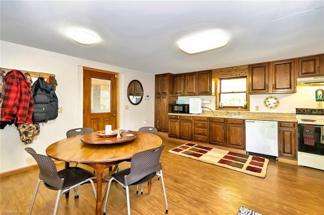 140 Blue Heron Ln, Wilkesboro, NC 28697 - kitchen with white appliances, under cabinet range hood, light countertops, light wood finished floors, and brown cabinets