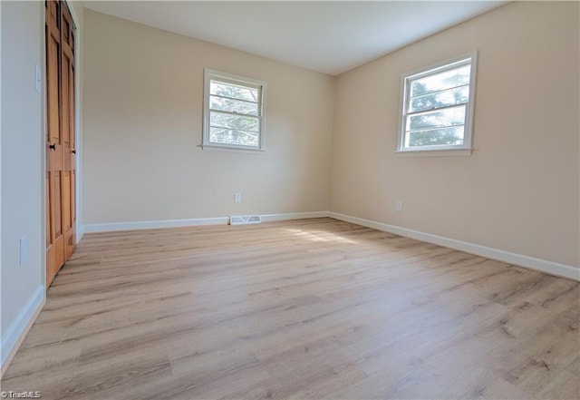 unfurnished room with baseboards, visible vents, and light wood-style floors
