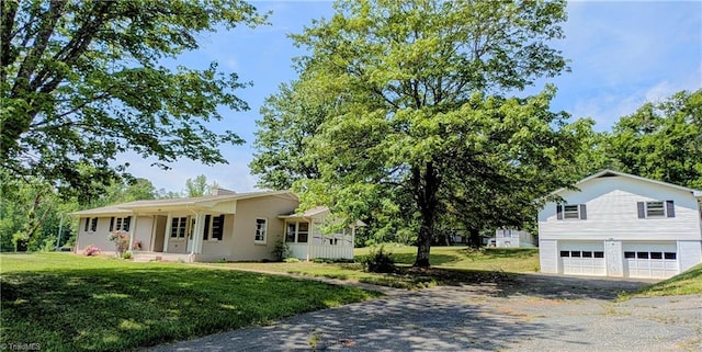 view of front of house featuring an attached garage, a front yard, and aphalt driveway