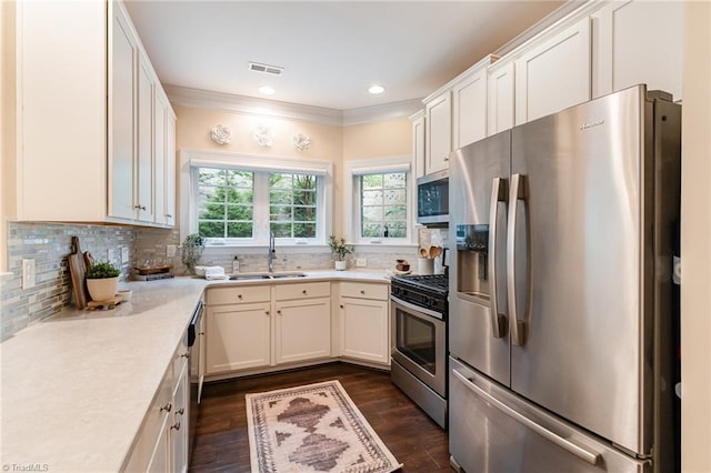 kitchen with white cabinetry, sink, backsplash, stainless steel appliances, and dark wood-type flooring