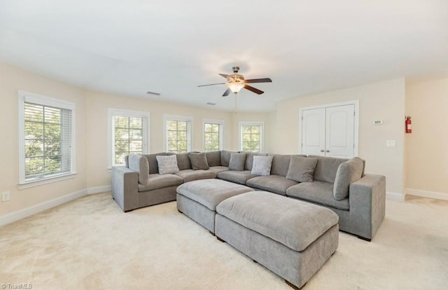 carpeted living room with ceiling fan