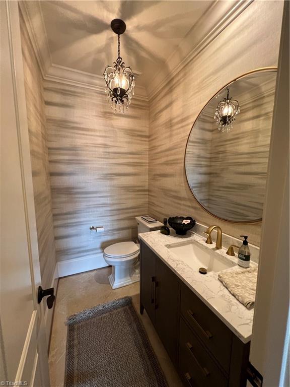 6792 Meadow View Dr, Summerfield, NC 27358 - half bathroom featuring vanity, a chandelier, ornamental molding, and wallpapered walls