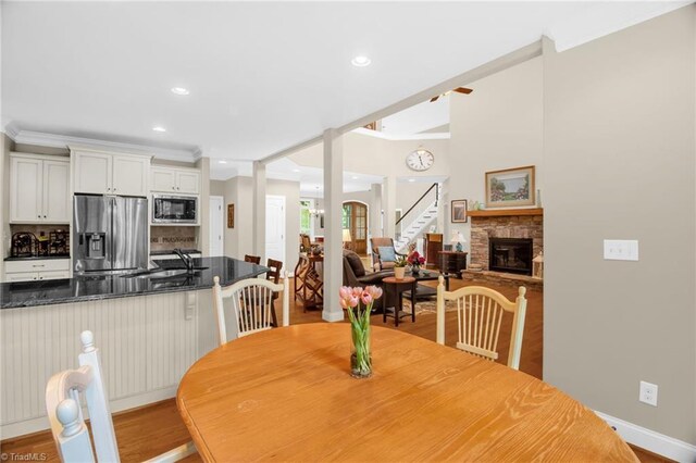 6122 Olde Fields Way, Pfafftown, NC 27040 - dining space featuring light wood-style flooring, a fireplace, stairway, baseboards, and recessed lighting