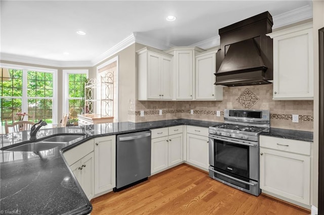 6122 Olde Fields Way, Pfafftown, NC 27040 - kitchen with stainless steel appliances, premium range hood, a sink, light wood-type flooring, and crown molding