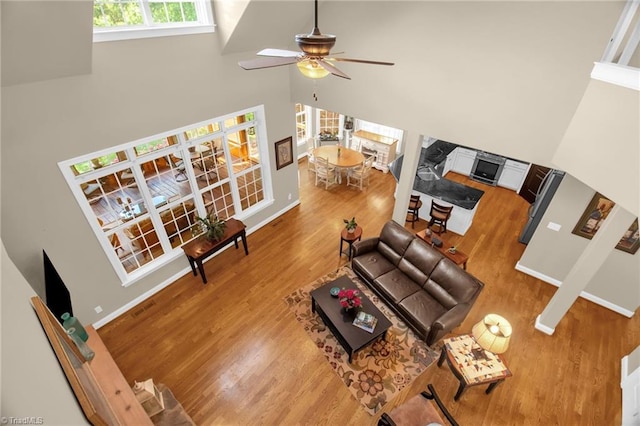 6122 Olde Fields Way, Pfafftown, NC 27040 - living area featuring a towering ceiling, wood finished floors, a ceiling fan, and baseboards
