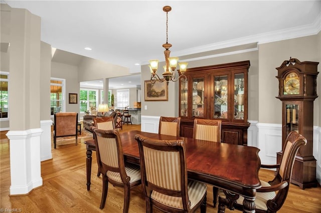 6122 Olde Fields Way, Pfafftown, NC 27040 - dining room with a chandelier, light wood-type flooring, wainscoting, decorative columns, and a decorative wall