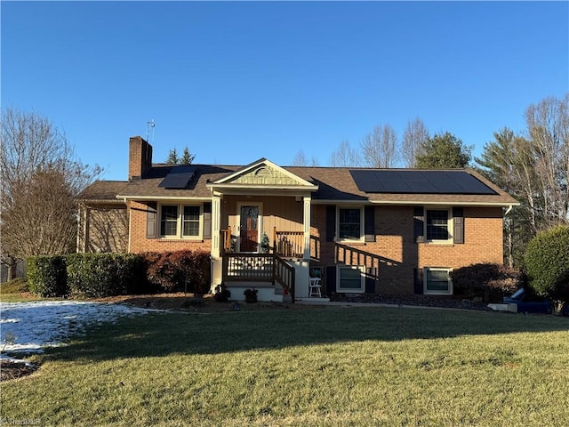 view of front of property with a front yard and solar panels