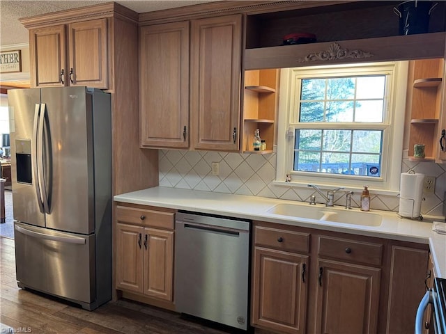 kitchen with hardwood / wood-style flooring, stainless steel appliances, tasteful backsplash, and sink