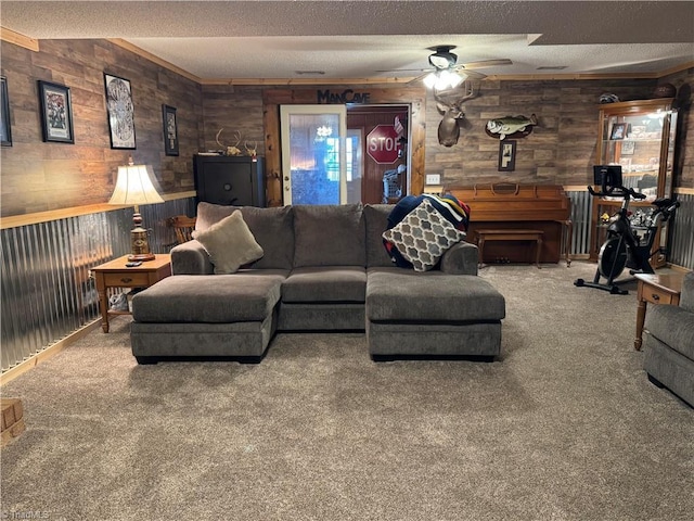 carpeted living room featuring ceiling fan, wood walls, and a textured ceiling