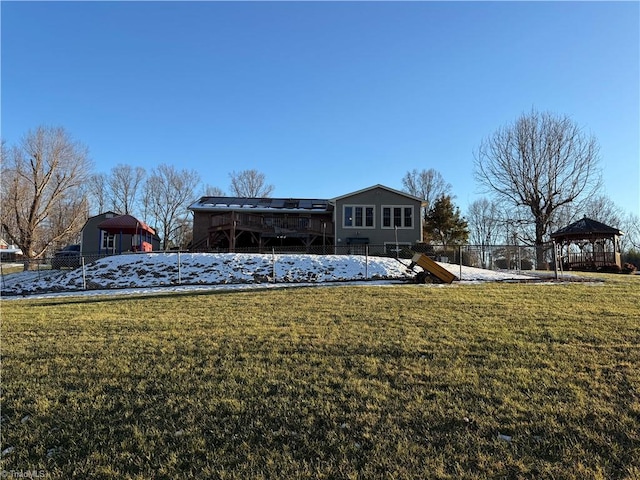 rear view of property with a lawn and a gazebo