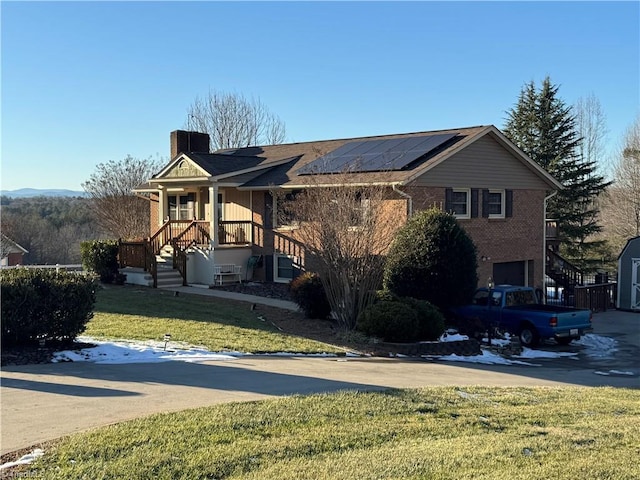 view of front of property with solar panels and a front yard