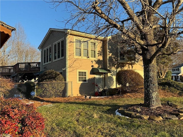 view of property exterior with a lawn and a deck