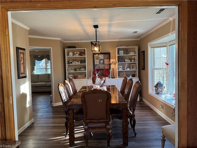 dining room featuring a textured ceiling, dark wood-type flooring, ornamental molding, and built in shelves