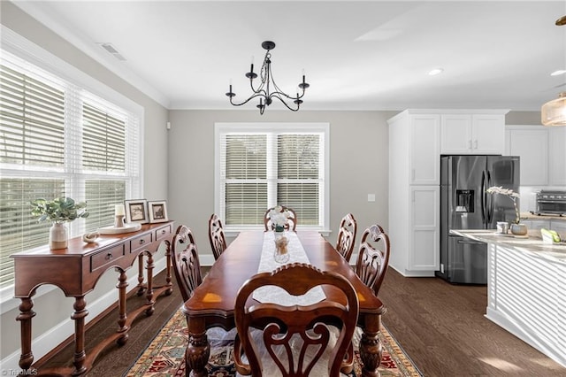 dining room with crown molding, plenty of natural light, an inviting chandelier, and dark hardwood / wood-style flooring