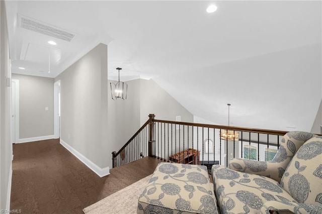 living area featuring lofted ceiling, dark wood-type flooring, and a chandelier