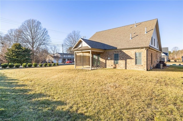 back of property with central AC and a lawn