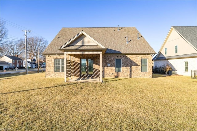 rear view of house featuring a lawn and a patio