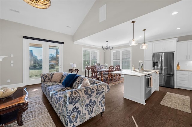 living room with dark hardwood / wood-style flooring, sink, high vaulted ceiling, and a chandelier