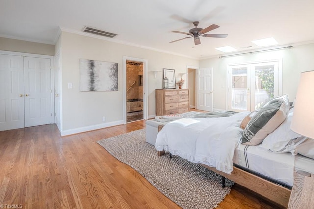 bedroom featuring crown molding, a skylight, light wood-type flooring, and access to outside