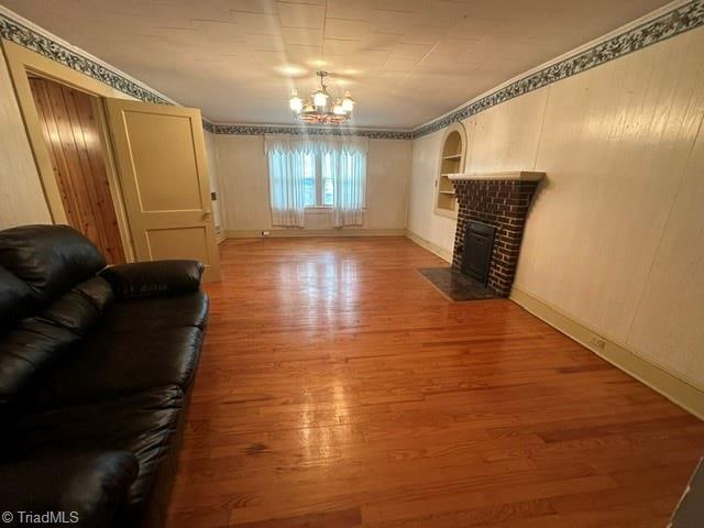 unfurnished living room with ornamental molding, a fireplace, and wood-type flooring