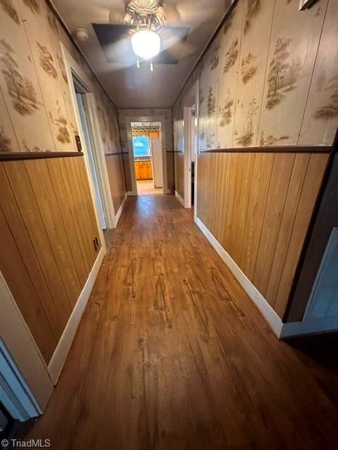 hall featuring wooden walls and wood-type flooring