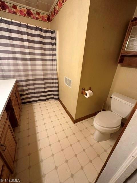 bathroom with vanity, toilet, and tile floors