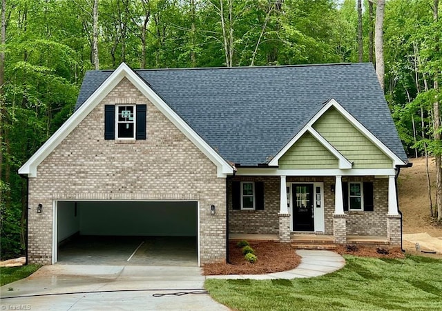 view of front of home featuring driveway, a porch, a shingled roof, a front lawn, and brick siding