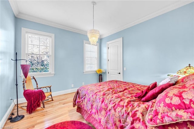 bedroom with multiple windows, hardwood / wood-style flooring, ornamental molding, and an inviting chandelier