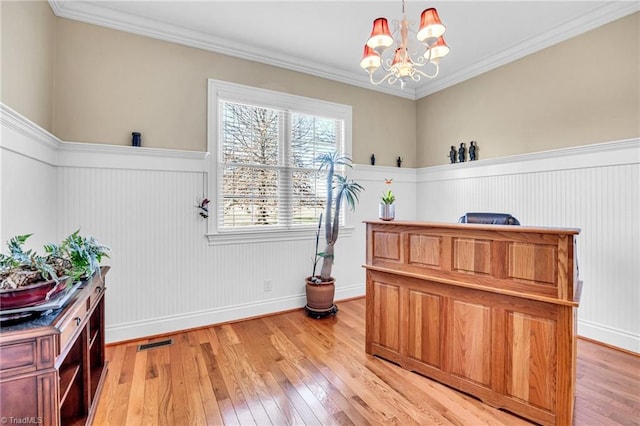 misc room featuring a notable chandelier, crown molding, and light hardwood / wood-style flooring